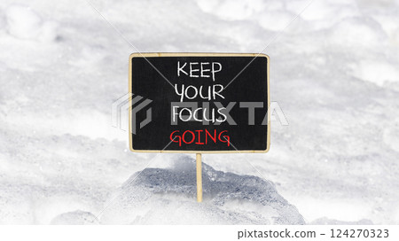Keep your focus going symbol. Concept words Keep your focus going on beautiful black blackboard. Beautiful snow background. Business and keep your focus going concept. Copy space 124270323