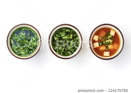 Three small bowls containing chopped parsley, coriander, and miso soup with tofu Three small bowls containing chopped parsley, coriander, and miso soup with tofu 124270780