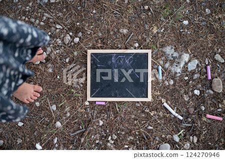 Chalk board and chalks on the ground 124270946