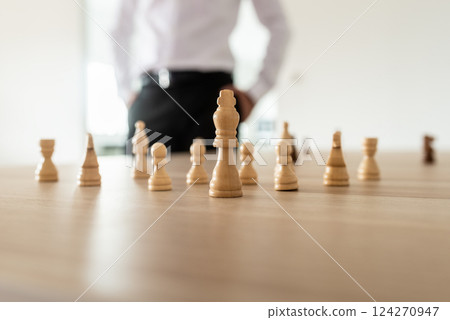 Chess pieces with king in the leading position placed on office desk Chess pieces with king in the leading position placed on office desk 124270947