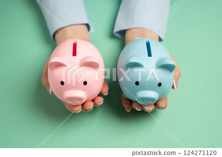 Piggy banks of opposite sexes in hands. Concept of difference in budgets of men and women. Joint family budget. Income gaps. Balanced financial planning Piggy banks of opposite sexes in hands. Concept of difference in budgets of men and women. Joint family budget. Income gaps. Balanced financial planning 124271120