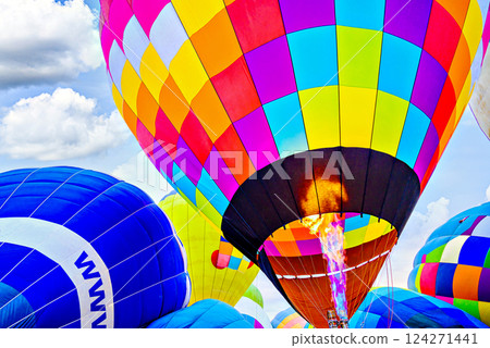 Colorful hot air balloon flying over blue sky with white clouds 124271441