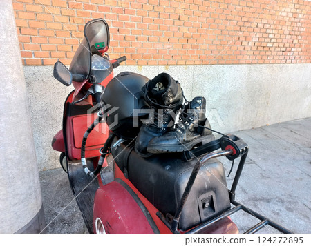 Adventure and travel concept with motorcycle and boots in urban setting Adventure and travel concept with motorcycle and boots in urban setting 124272895