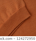 Elastic band close up on the sleeve of a terracotta orange knitted cotton polo t-shirt 124272950