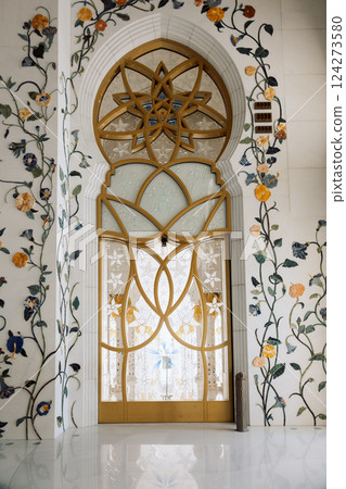 View of Sheikh Zayed Grand Mosque in Abu Dhabi made of white marble with flowers made of precious stones in design. Inside mosque. Vertical photo 124273580