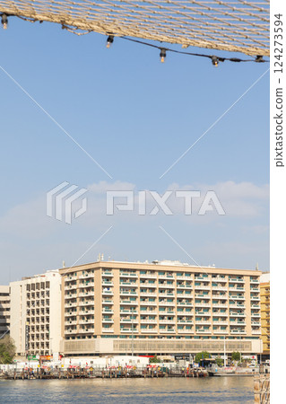 Old town in Al Seef Cultural Historical District. Beautiful view of water, old houses and new ones of Dubai Creek, Dubai, UAE. Taken off hand. Vertical photo. High quality photo 124273594