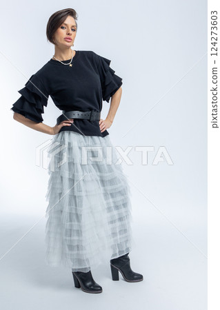 Beautiful model in black jumper, light grey skirt on white background. High fashion. Vertical photo. High quality photo Beautiful model in black jumper, light grey skirt on white background. High fashion. Vertical photo. High quality photo 124273603