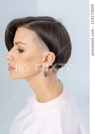 Close-up of girl's earring in her ear. Beautiful jewelry women's decoration. Studio photography. Vertical photo. High quality photo Close-up of girl's earring in her ear. Beautiful jewelry women's decoration. Studio photography. Vertical photo. High quality photo 124273609