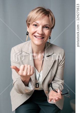 Portrait of happy woman. Confident, successful mature woman on light gray background. Looking at camera. High quality photo Portrait of happy woman. Confident, successful mature woman on light gray background. Looking at camera. High quality photo 124273613