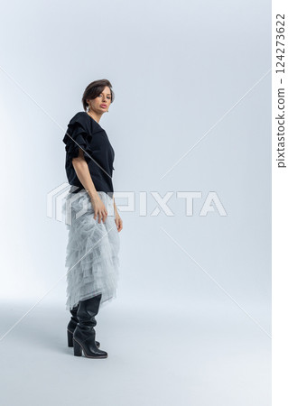 Beautiful model in black jumper, light grey skirt on white background. High fashion. Vertical photo. High quality photo Beautiful model in black jumper, light grey skirt on white background. High fashion. Vertical photo. High quality photo 124273622