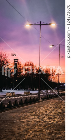 Fantastic winter landscape at fiery dawn. Silhouette of lighthouse and walking paths in park 300 anniversary of St. Petersburg, Russia. Vertical photo. Fantastic winter landscape at fiery dawn. Silhouette of lighthouse and walking paths in park 300 anniversary of St. Petersburg, Russia. Vertical photo. 124273670