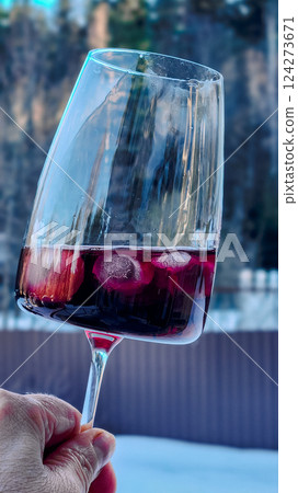 Female hand with glass of red wine against backdrop of nature. Vertical photo. High quality photo Female hand with glass of red wine against backdrop of nature. Vertical photo. High quality photo 124273671