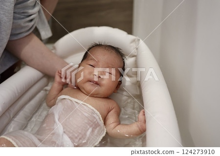 A newborn baby under one month old being bathed. A newborn baby under one month old being bathed. 124273910
