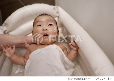 Newborn baby in bath, washing face Newborn baby in bath, washing face 124273912