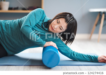 一名女子使用拉伸桿進行鍛煉 124274416