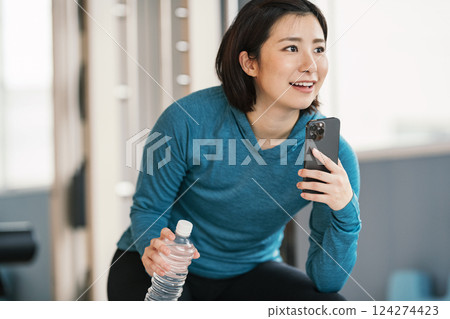 Woman taking a break at the gym Woman taking a break at the gym 124274423
