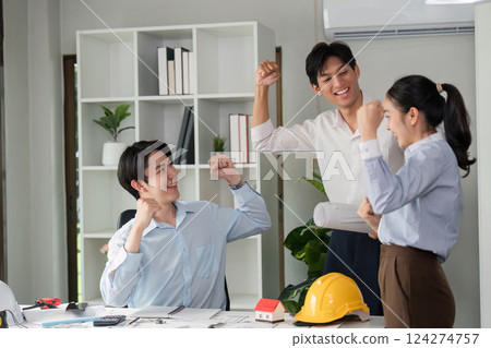 Team Collaboration and Celebration. Two colleagues celebrate their successful project completion in a modern office. 124274757