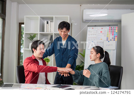 Creative Team Dynamics and Engagement. A group of young designers collaborating on ideas in a modern office environment. 124274791