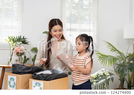 Recycling and Environmental Awareness. Two girls are engaged in sustainable practices, recycling plastic items with enthusiasm. 124274800