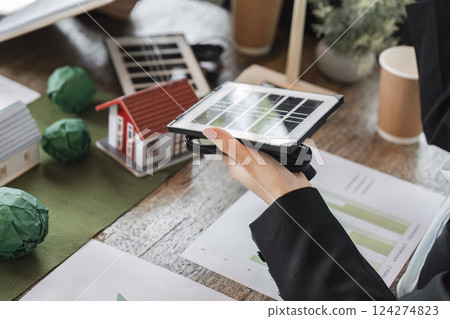 Sustainable Development and Solar Technology. A team reviewing solar technology for improving energy efficiency in homes. 124274823