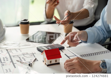 Building Design and Teamwork. Collaborative discussion around housing project plans with a focus on a model house. 124274881