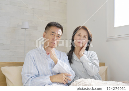Couple in pajamas thinking Couple in pajamas thinking 124274931