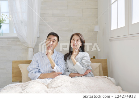 Middle-aged couple imagining in bed 124274938