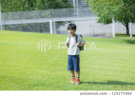 Elementary school student carrying a backpack walking outdoors 124275460