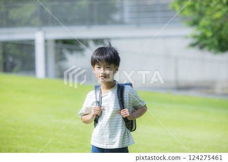 Elementary school student carrying a backpack walking outdoors 124275461