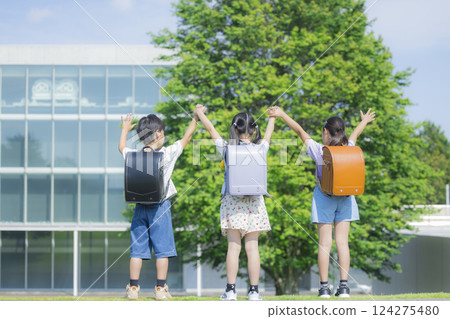 Elementary school student carrying a backpack walking outdoors Elementary school student carrying a backpack walking outdoors 124275480