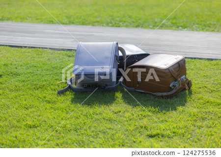 School bag on green grass School bag on green grass 124275536