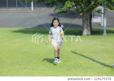 Elementary school student carrying a backpack walking outdoors Elementary school student carrying a backpack walking outdoors 124275570