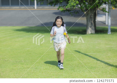 背著書包在戶外散步的小學生 背著書包在戶外散步的小學生 124275571
