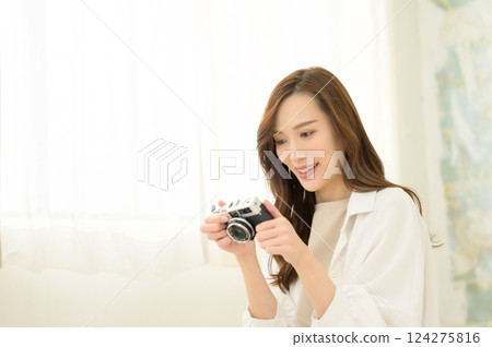 Woman holding a classic camera Woman holding a classic camera 124275816