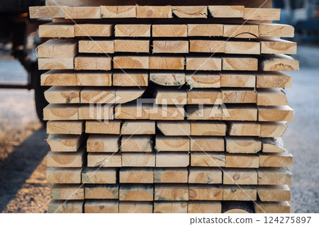 Wooden planks stacked neatly, creating a textured lumber background, potentially at a sawmill or construction site in russia Wooden planks stacked neatly, creating a textured lumber background, potentially at a sawmill or construction site in russia 124275897