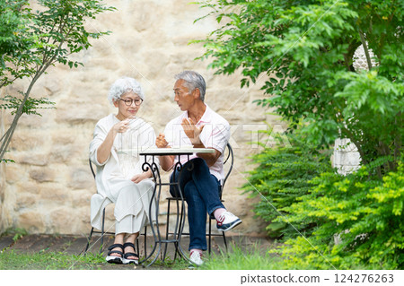 Senior couple sitting on a bench drinking tea 124276263
