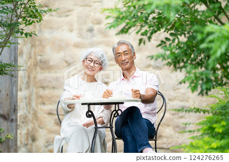 一對老夫婦坐在長椅上喝茶 124276265