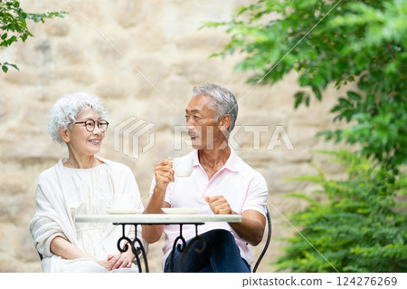 Senior couple sitting on a bench drinking tea Senior couple sitting on a bench drinking tea 124276269
