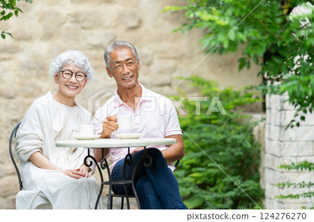 一對老夫婦坐在長椅上喝茶 124276270