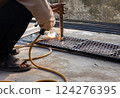 Welder is welding add joint at a construction site weld metal structures of  Steel frames and grids for use in construction. 124276395