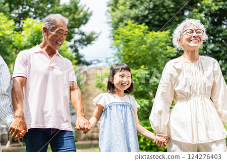 Senior couple walking hand in hand with their grandchild Senior couple walking hand in hand with their grandchild 124276403