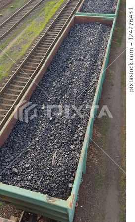 Open wagon transporting coal along railway tracks 124276431