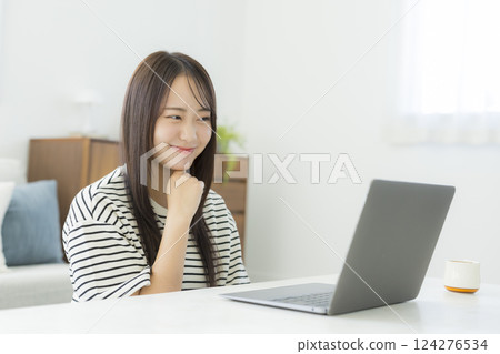 Young woman using a computer in the living room 124276534