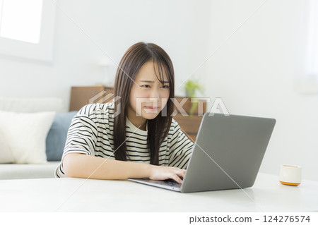 Young woman using a computer in the living room 124276574