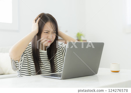 Young woman using a computer in the living room 124276578