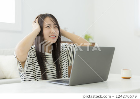 Young woman using a computer in the living room 124276579