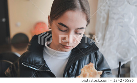 Woman enjoying fresh flatbread, relaxing in warm cafe, embodying culinary comfort and serene personal dining experience Woman enjoying fresh flatbread, relaxing in warm cafe, embodying culinary comfort and serene personal dining experience 124276586