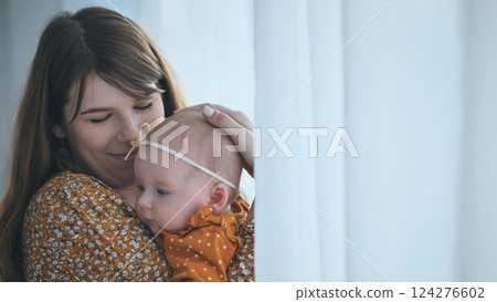 Loving mother holding newborn, sunlight filtering through delicate curtains, tender embrace capturing maternal bond and gentle affection Loving mother holding newborn, sunlight filtering through delicate curtains, tender embrace capturing maternal bond and gentle affection 124276602