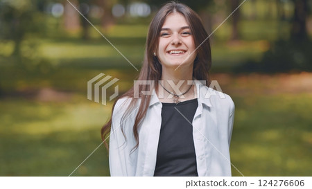 Cheerful georgian female resting amid verdant park landscape, basking in warm summer sunlight and lush greenery 124276606