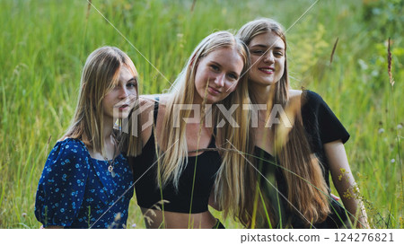 Three school friends enjoying a sunny day in a field, embracing their bond amidst nature's beauty Three school friends enjoying a sunny day in a field, embracing their bond amidst nature's beauty 124276821